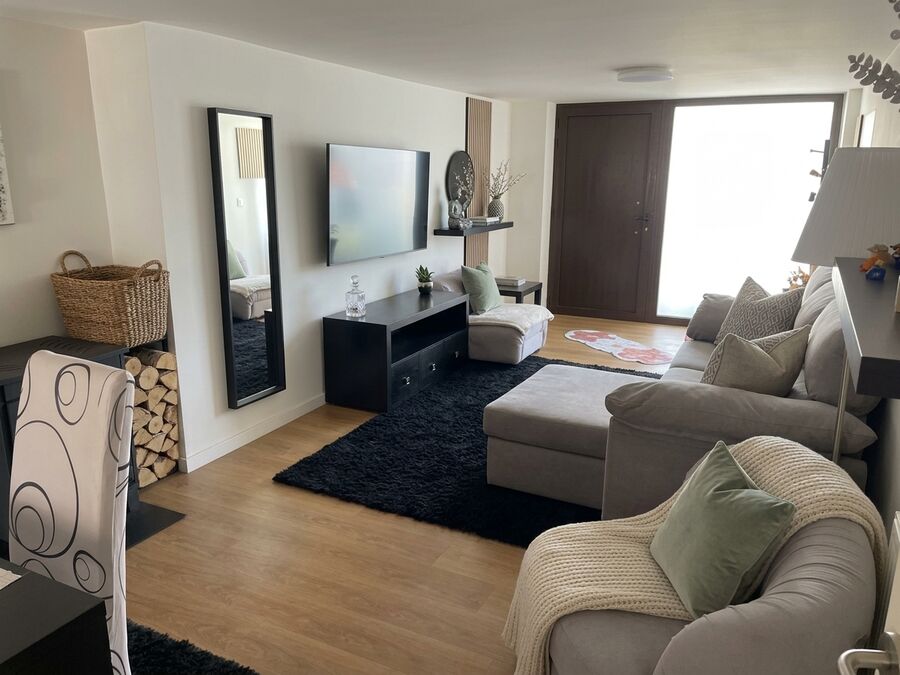 Sala de estar espaçosa do apartamento T2 em Ofir com sofá amplo e TV